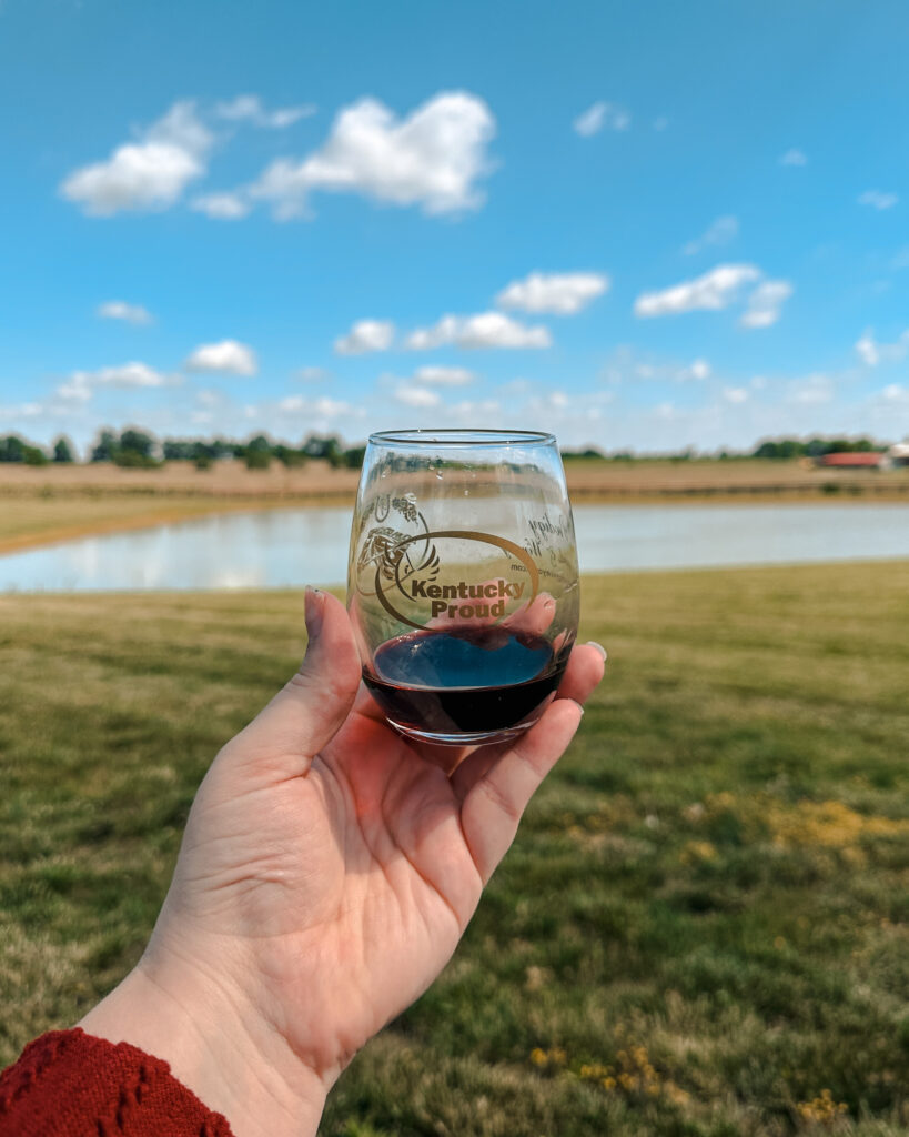 A glass of wine against the rolling hills of Kentucky