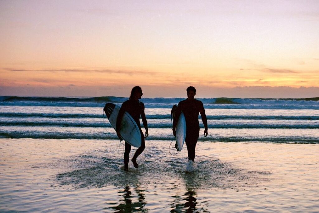 surfers on the beach during a november sunset in ericeira
