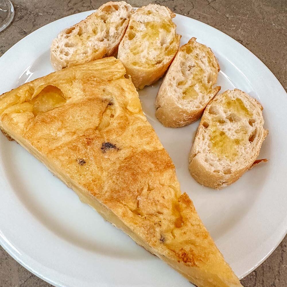 Spanish tortilla served with crusty bread and olive oil.