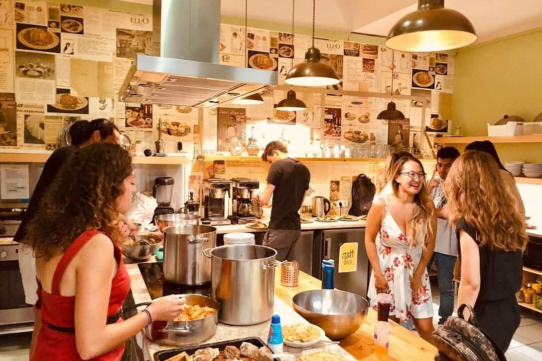 solo travellers cooking food together at good morning lisbon hostel